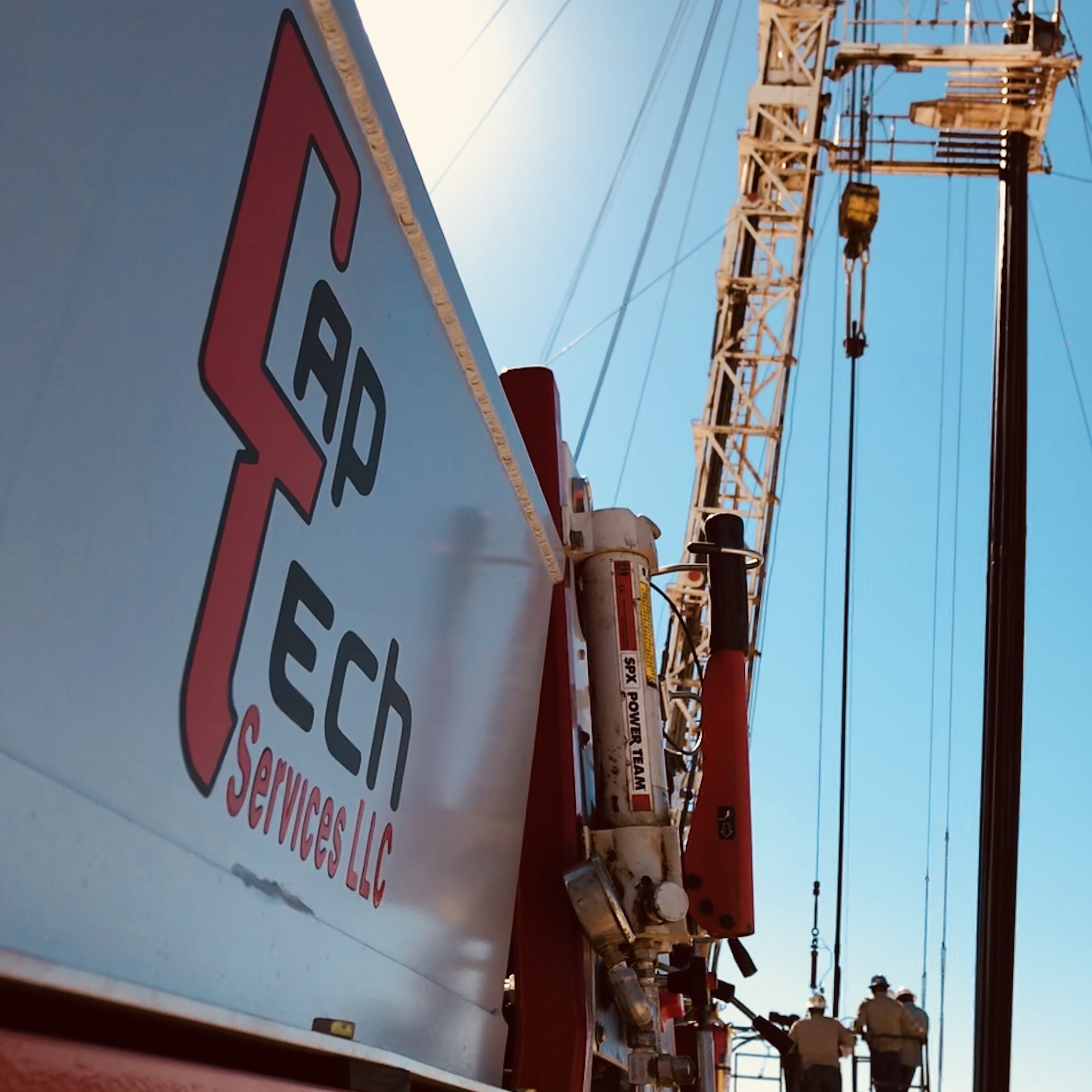 View of a crane lifting near a Rap Tech company sign under a clear sky.