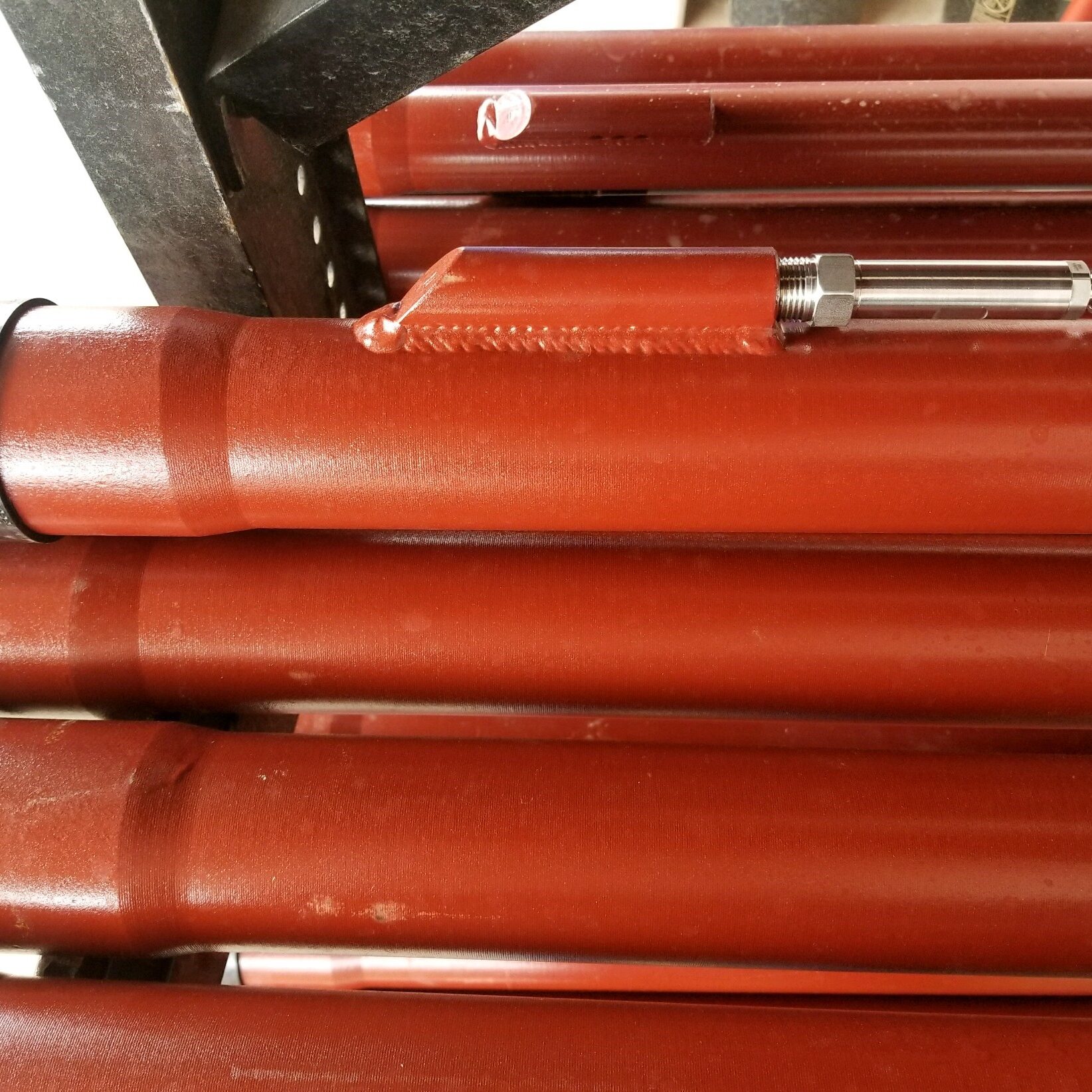 Close-up of orange hydraulic cylinders stacked together.